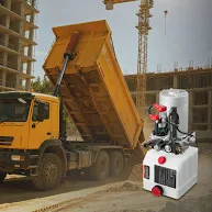 A double acting hydraulic power unit shown alongside a dump truck lifting its trailer.