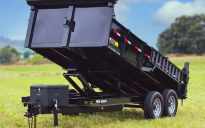 Heavy duty black dump trailer in a raised position on grass, demonstrating the practical application of a Dump Trailer Hydraulic Pump.