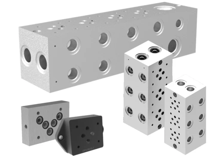 Multiple high-precision aluminum and steel hydraulic manifold blocks for industrial fluid power systems.
